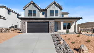 View of front of house featuring a garage, stone siding, concrete driveway, covered porch, and board and batten siding