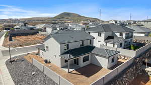 Back of property featuring a residential view, a fenced backyard, stucco siding, a patio area, and a mountain view