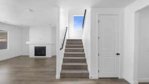 Stairway featuring a large fireplace and wood finished floors
