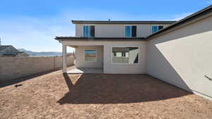 Back of house featuring a patio, a mountain view, and stucco siding