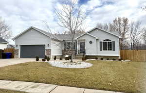 Ranch-style house with driveway, a garage, and brick siding