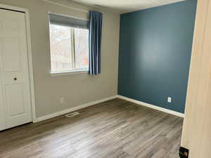 Unfurnished bedroom featuring light wood-style floors and a closet