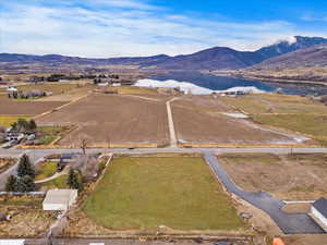 Aerial view of property and surrounding area featuring a water and mountain view and rural landscape