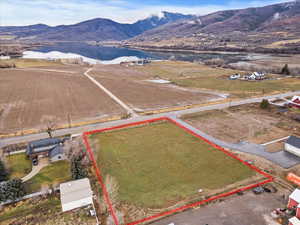 Aerial view of property and surrounding area with a water and mountain view and property boundaries highlighted