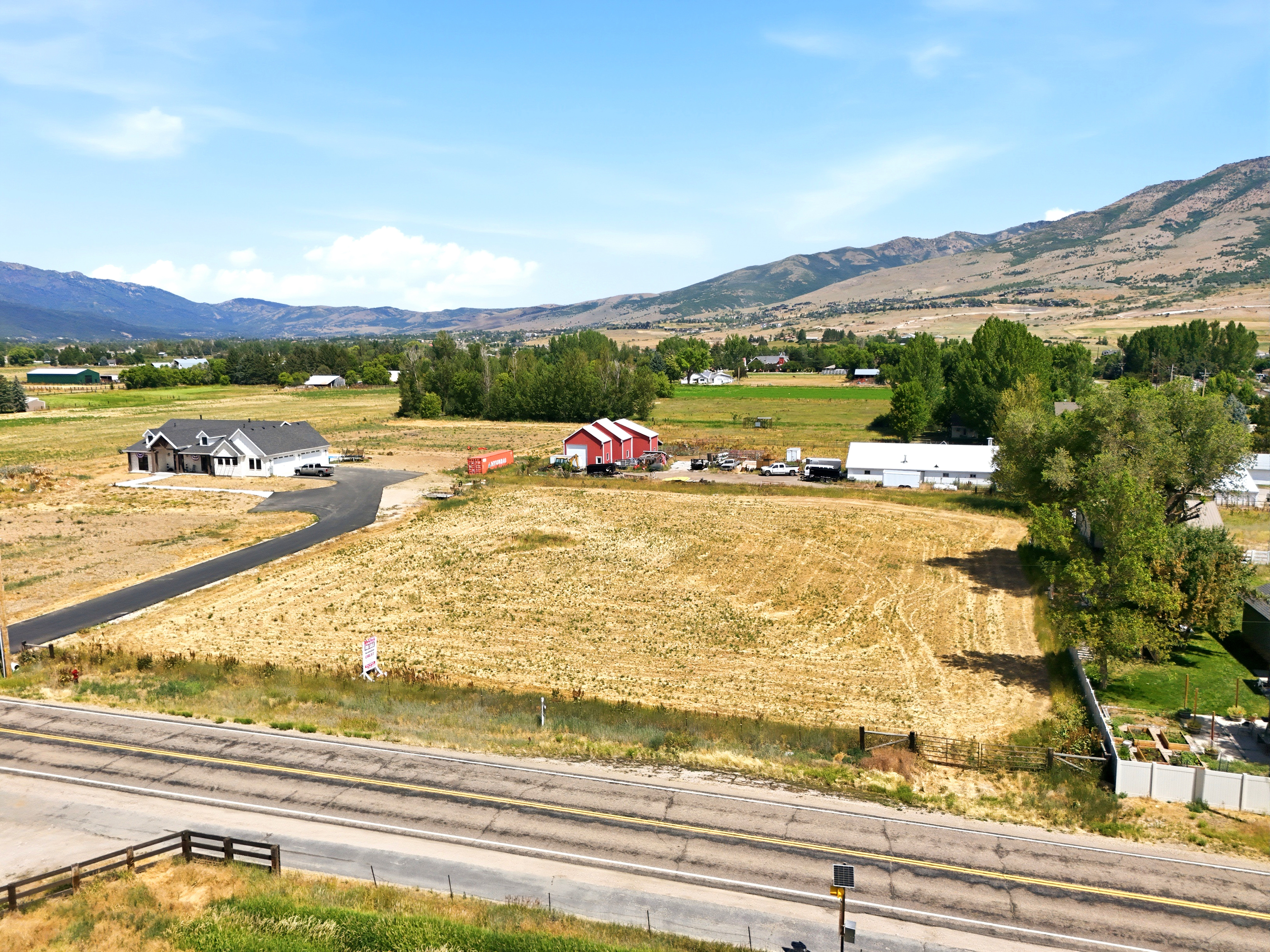 Expansive undeveloped lot with a paved road frontage, offering a clear building site
