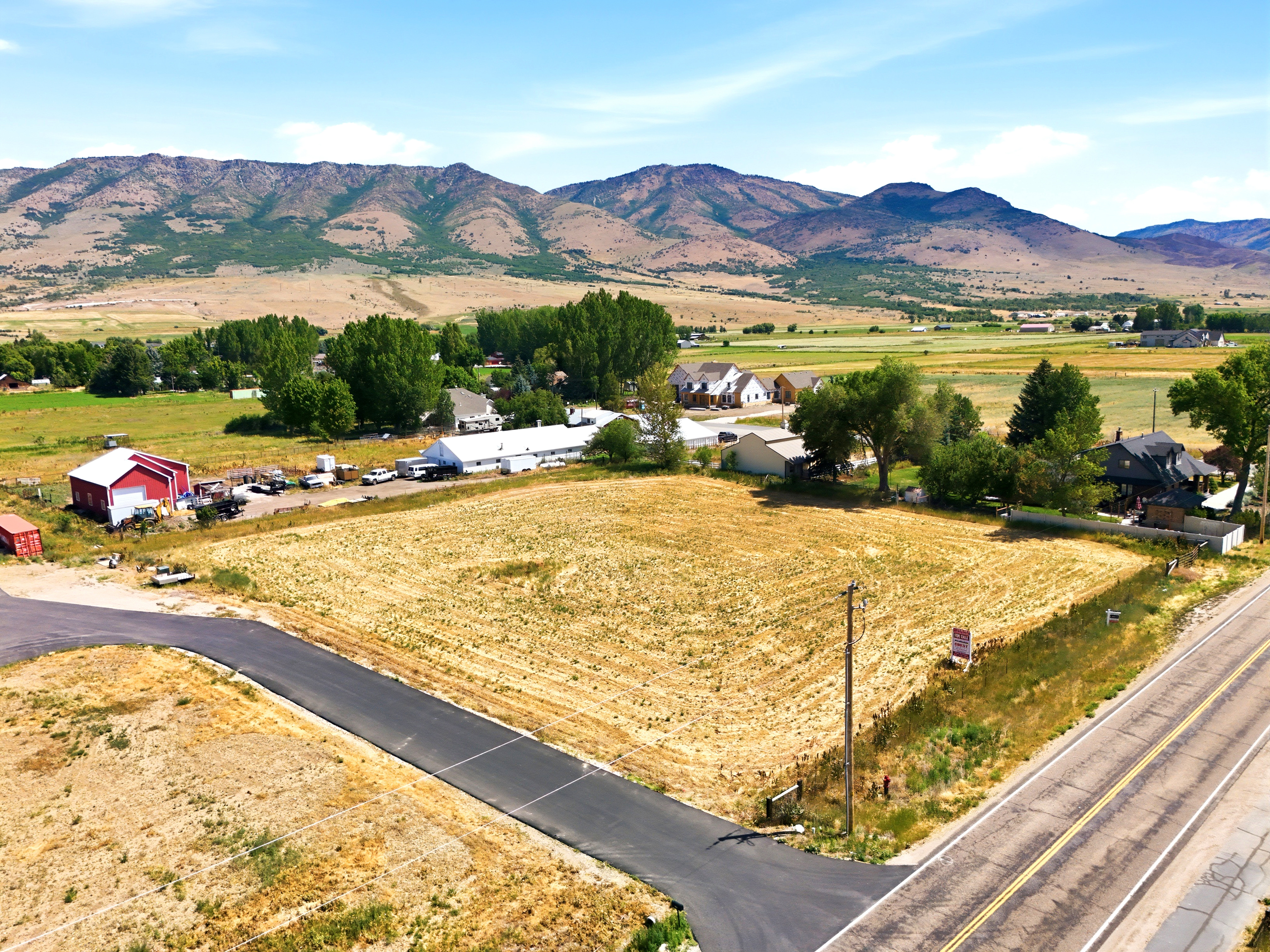 Expansive undeveloped lot featuring a paved road frontage and mountain scenery