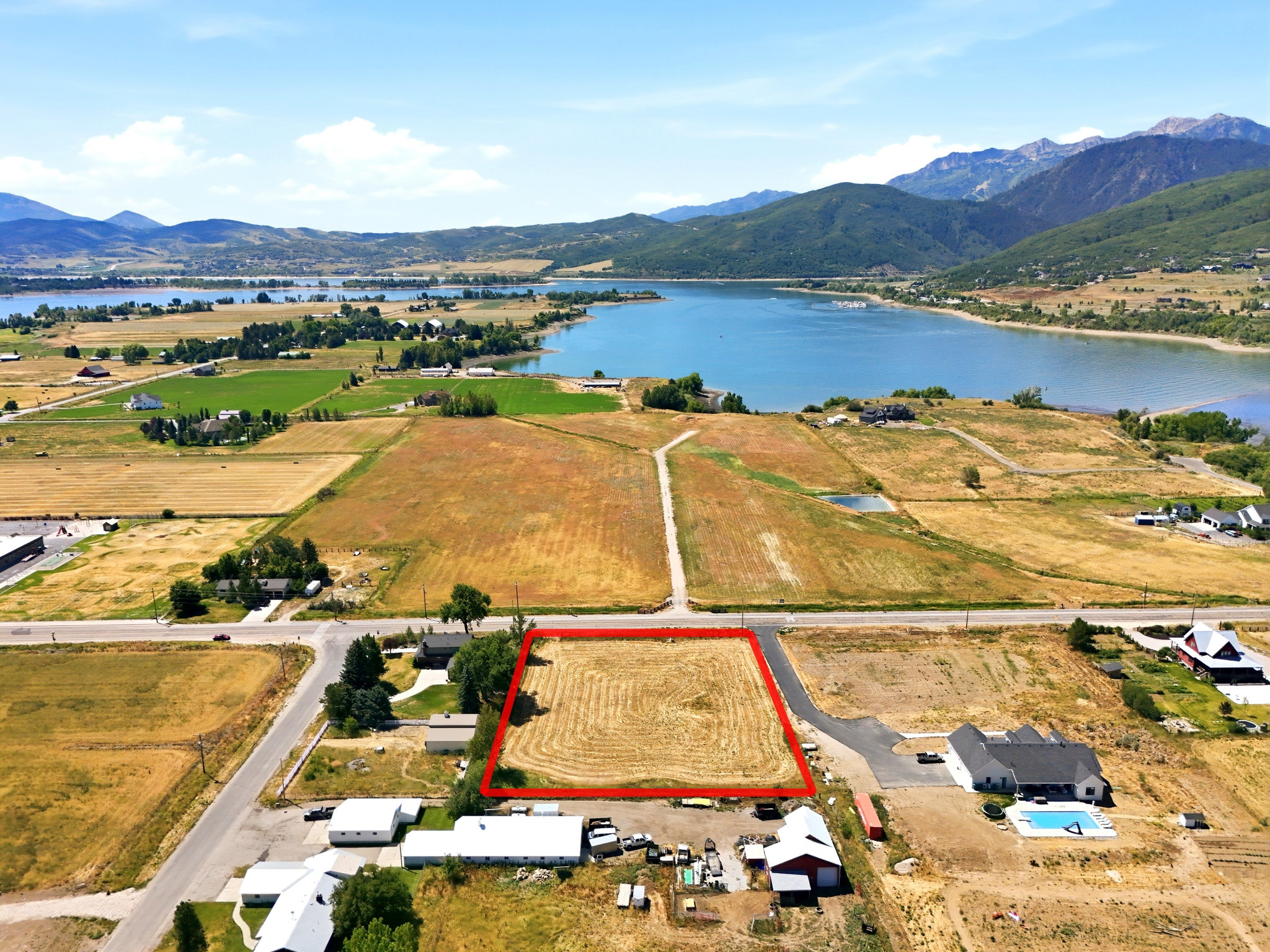 Expansive land parcel featuring direct road frontage and distant mountain and lake scenery