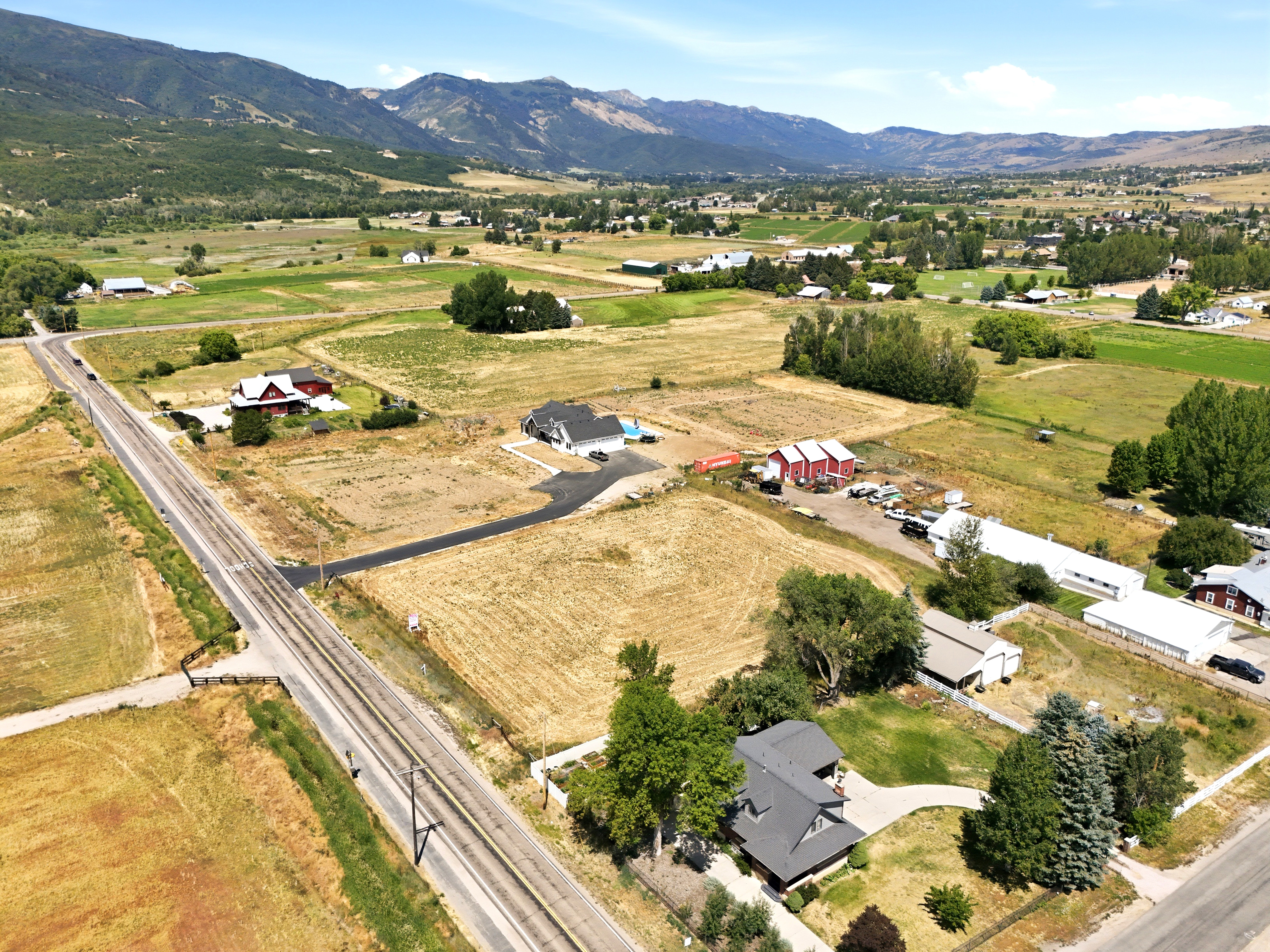 Expansive rural landscape featuring a prominent road and railway lines