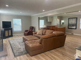 Living room featuring recessed lighting, wood finished floors, plenty of natural light, and crown molding