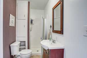 Full bath with vanity, a stall shower, and a textured ceiling