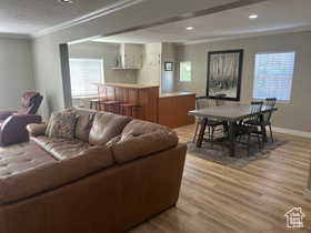 Living area with a textured ceiling, crown molding, wood finished floors, and healthy amount of natural light