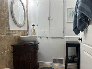 Bathroom with tile walls and vanity