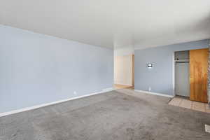Carpeted empty room featuring baseboards