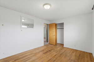 Unfurnished bedroom with a closet and light wood finished floors