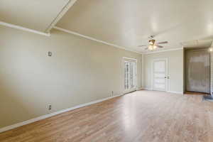 Empty room with light wood finished floors, ornamental molding, and a ceiling fan