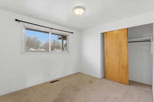 Unfurnished bedroom featuring a closet and carpet flooring
