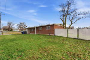 Rear view of house with a fenced backyard and brick siding
