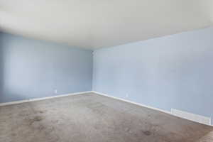 Empty room with carpet and baseboards