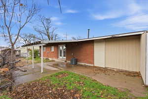 Rear view of property featuring a patio area, french doors, and brick siding