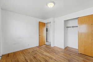 Unfurnished bedroom featuring a closet and hardwood / wood-style flooring