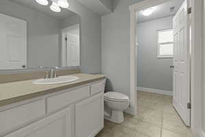 Bathroom with vanity, light tile patterned flooring, and a textured ceiling