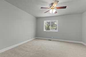 Empty room with a textured ceiling, light colored carpet, and ceiling fan