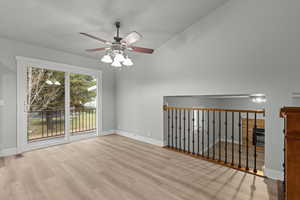 Empty room featuring light wood-type flooring, a ceiling fan, lofted ceiling, and a textured ceiling