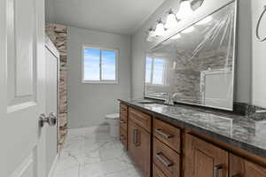 Full bathroom featuring light marble finish floors, vanity, a textured ceiling, and a shower