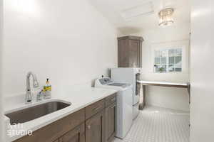 Laundry area with washer and dryer, attic access, cabinet space, and light tile patterned floors