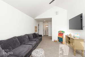 Living room featuring light carpet, high vaulted ceiling, and a ceiling fan