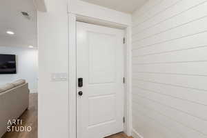 Doorway to outside featuring baseboards and wood finished floors