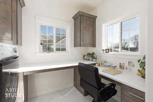 Office space featuring built in desk and washer / dryer