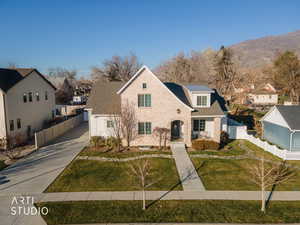 View of front of house with concrete driveway, brick siding, a mountain view, and a residential view