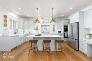 Kitchen featuring a breakfast bar area, appliances with stainless steel finishes, pendant lighting, tasteful backsplash, and recessed lighting