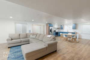 Living room with light wood-style flooring and recessed lighting