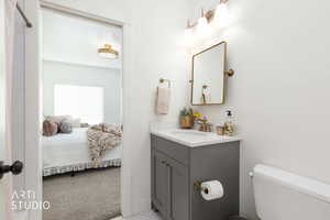 Ensuite bathroom with light colored carpet and vanity