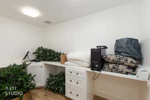 Office featuring built in desk and light wood finished floors