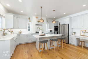 Kitchen with appliances with stainless steel finishes, a breakfast bar, pendant lighting, and decorative backsplash