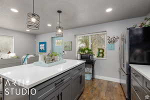 Kitchen featuring stainless steel appliances, gray cabinetry, pendant lighting, recessed lighting, and a textured ceiling