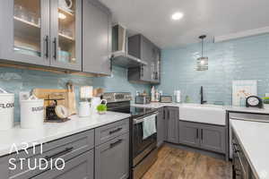 Kitchen with gray cabinets, electric stove, decorative light fixtures, a textured ceiling, and recessed lighting