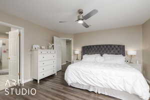 Bedroom featuring wood finished floors, a ceiling fan, and ensuite bath