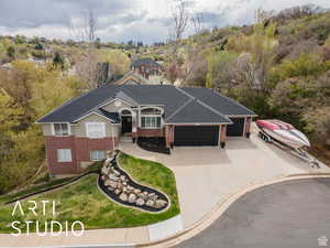 View of front of house with brick siding, concrete driveway, an attached garage, and a shingled roof