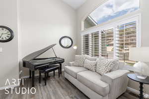 Living area featuring plenty of natural light, wood finished floors, and vaulted ceiling