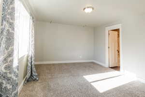 Carpeted empty room with baseboards