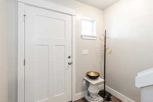 Doorway to outside featuring baseboards and wood finished floors