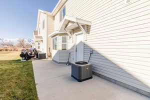 View of side of property featuring a lawn, a patio, and a mountain view