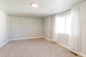 Unfurnished room featuring light colored carpet and baseboards
