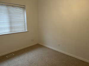 Carpeted spare room with baseboards