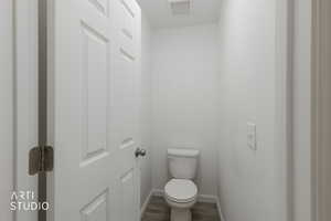 Bathroom featuring toilet and wood finished floors