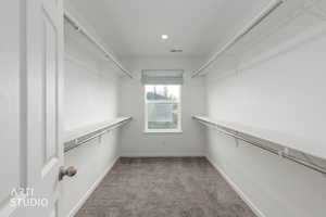 Walk in closet featuring light carpet